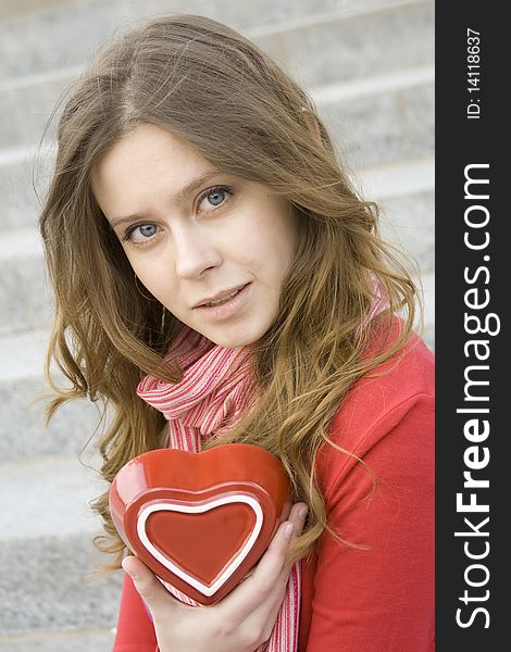 A beautiful young woman holding a red heart. Valentine. A beautiful young woman holding a red heart. Valentine