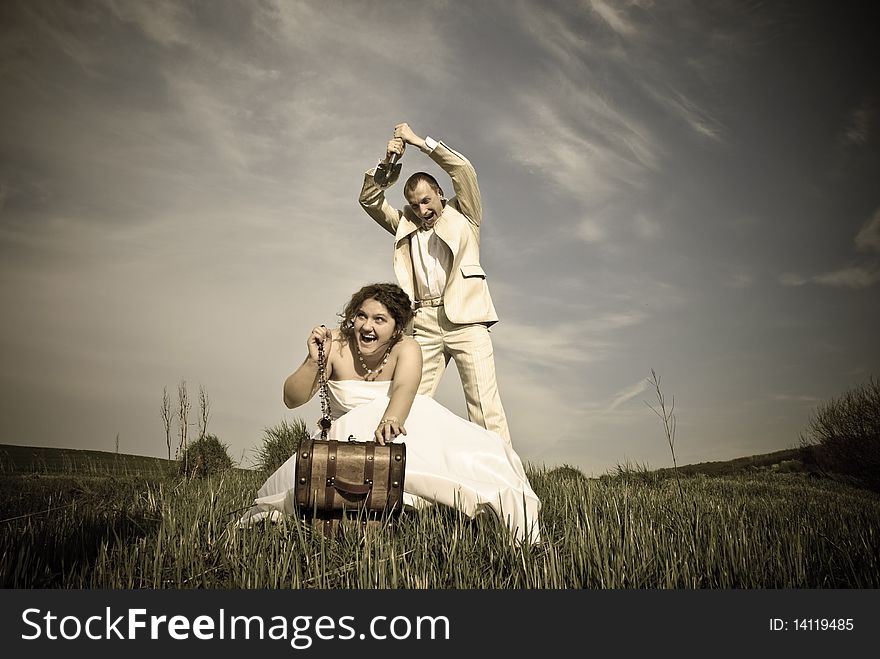 Wedding couple and treasure box at spring meadow hill