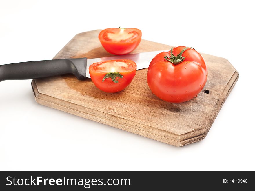 Fresh tomatoes and a knife on a worktop