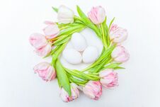 Easter Eggs In Nest And Pink Fresh Tulip Bouquet On Rustic White Wooden Background Stock Photo