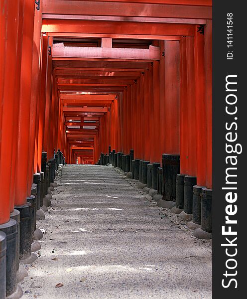 Japanese shrine entrance with red columns and black roofs background