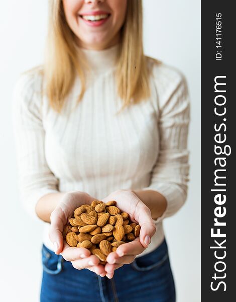 Cheerful young woman hands holding almonds nuts on white background