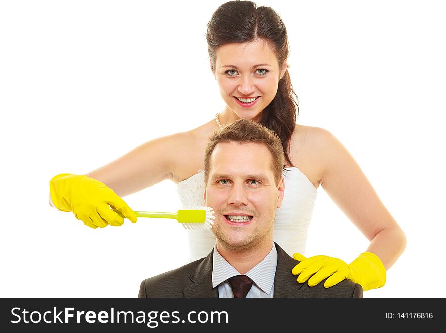 Taking care of house together, sharing household duties concept. Bride in wedding dress and groom wearing elegant suit holding cleaning equipment and tools. Taking care of house together, sharing household duties concept. Bride in wedding dress and groom wearing elegant suit holding cleaning equipment and tools