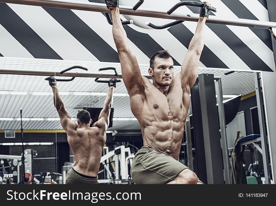 Guy bodybuilder , perform exercise do chin-ups, horizontal bar in gym. Guy bodybuilder , perform exercise do chin-ups, horizontal bar in gym