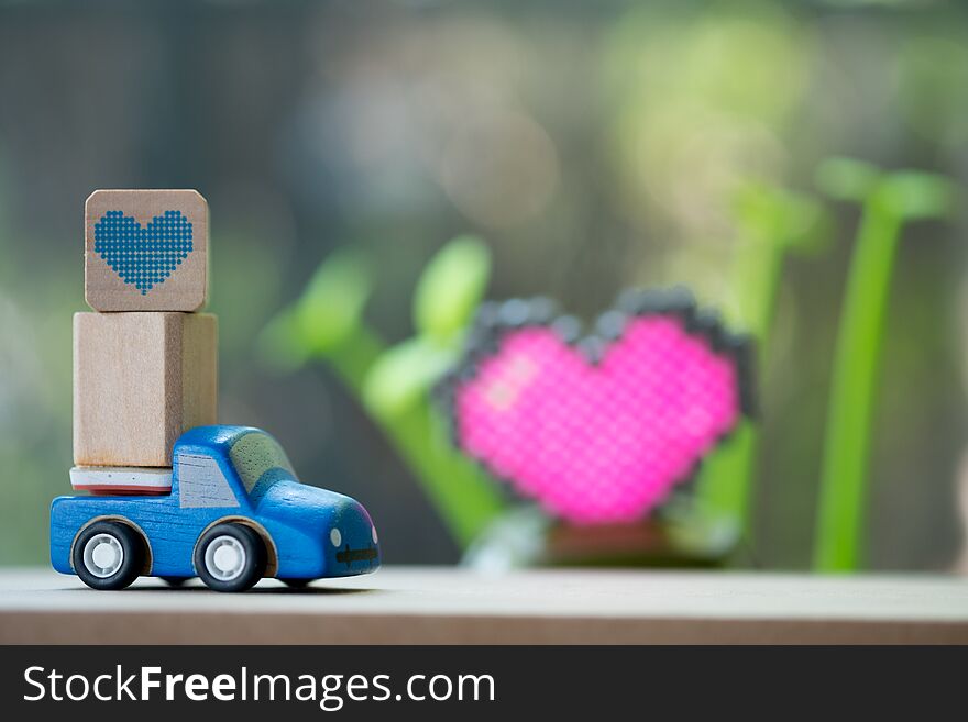Miniature toy car carrying a heart delivering for Valentine`s day. Miniature toy car carrying a heart delivering for Valentine`s day
