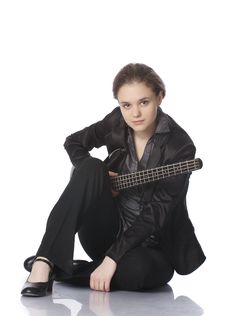 Seated Girl With A Black Electric Bass Guitar Royalty Free Stock Photos