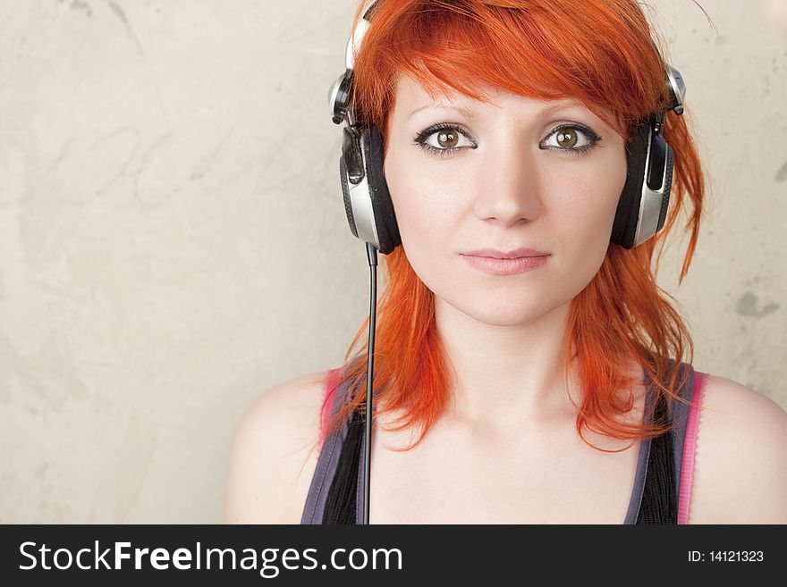 Young woman with headphones posing on a vintage background. Young woman with headphones posing on a vintage background