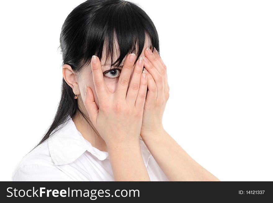 Young woman  is gazing through her fingers on a white background