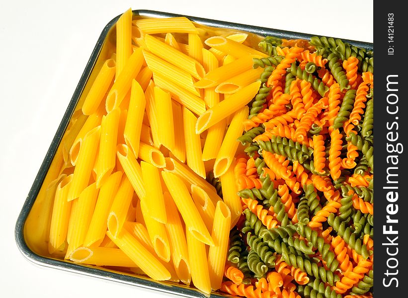 Two varieties of pasta on a silver tray. Two varieties of pasta on a silver tray