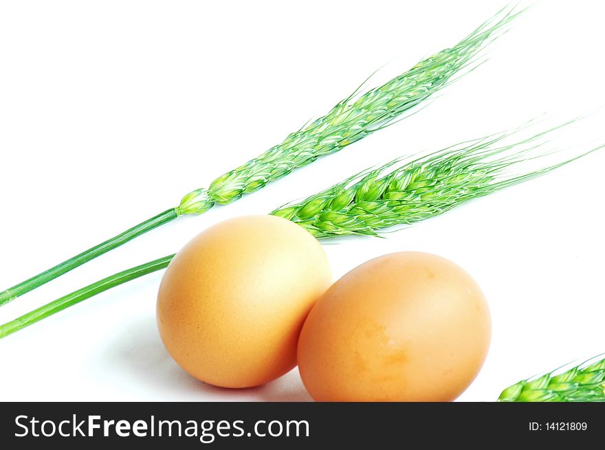 Eggs and green wheat ears isolated on white background. Eggs and green wheat ears isolated on white background