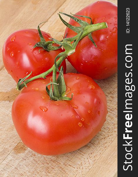 Fresh tomatoes on wooden cutting board