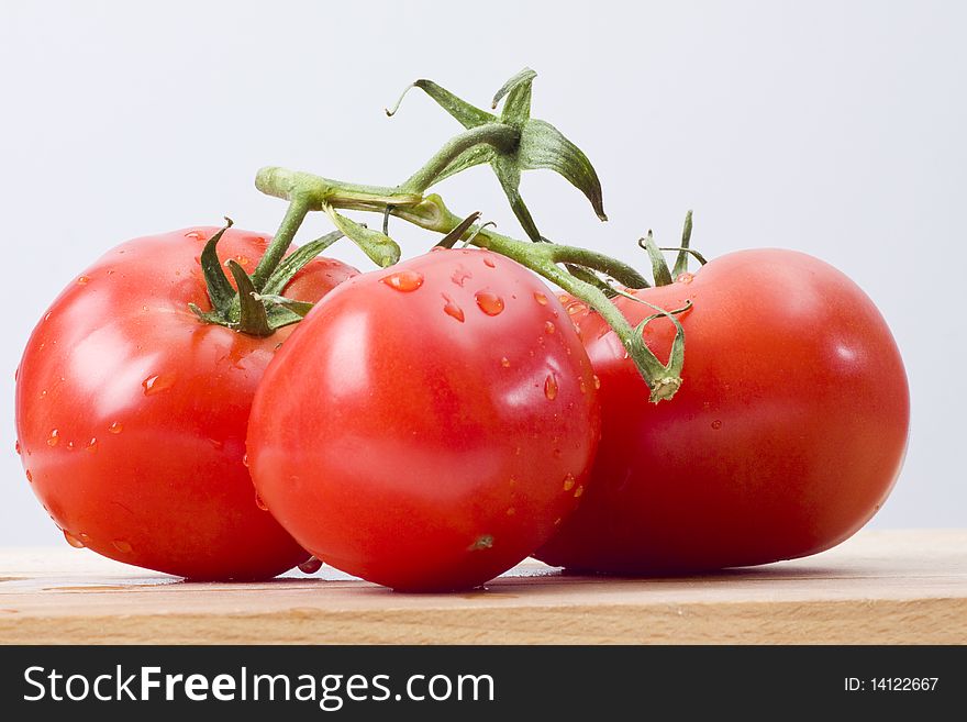 Fresh tomatoes on wooden cutting board