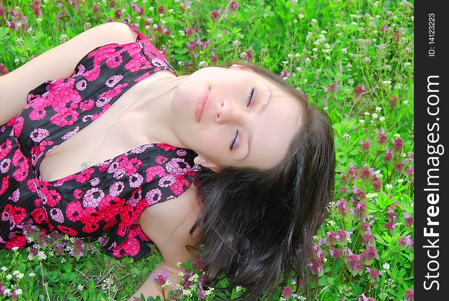 The beautiful girl walks on a solar meadow