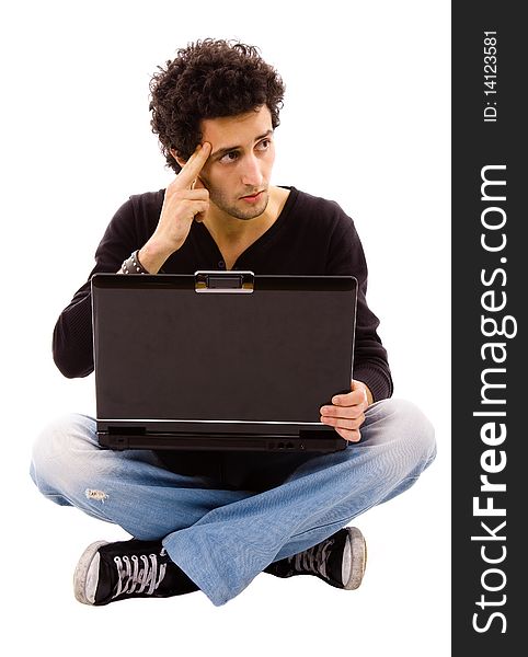 Pensive young man sitting on floor using laptop, isolated on white