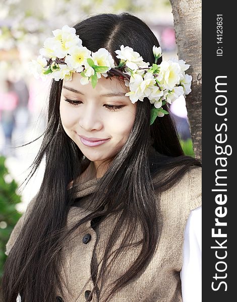 Asian girl in garland smiling in spring.