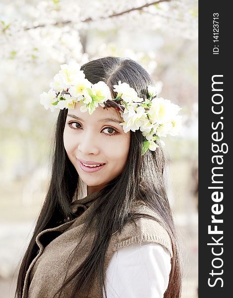 Beautiful Asian girl in garland under cherry tree.