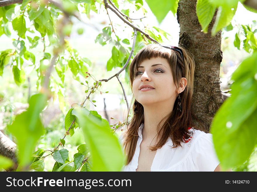 Beautiful young girl enjoying the sunny day in an orchard. Beautiful young girl enjoying the sunny day in an orchard