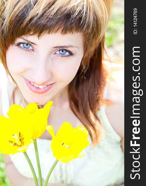 Beautiful young woman portrait holding yellow tulips. Beautiful young woman portrait holding yellow tulips