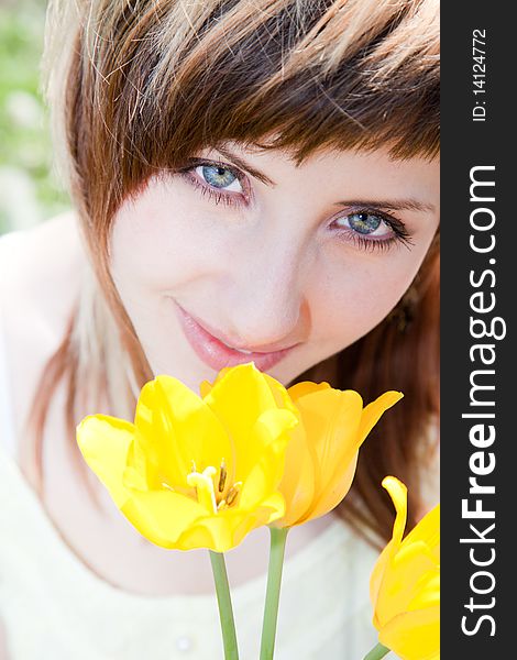 Beautiful young woman portrait holding yellow tulips. Beautiful young woman portrait holding yellow tulips