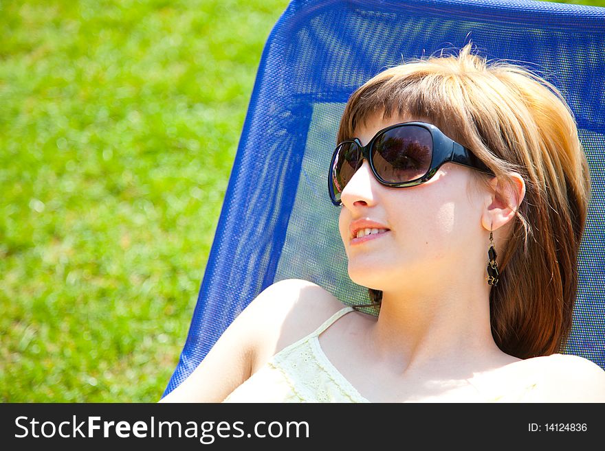 Beautiful young woman relaxing on a chair in the sun. Beautiful young woman relaxing on a chair in the sun.