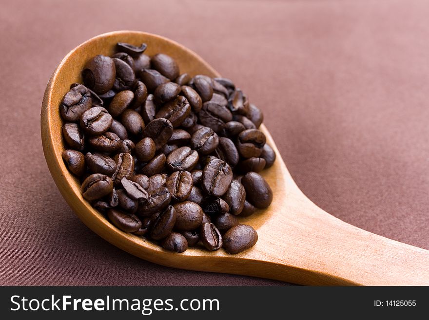 Fresh roasted,coffee beans in the spoon,close up
