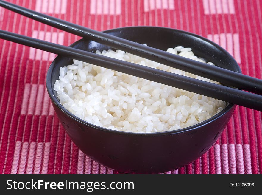Plain rice bowl, chopsticks, on red background