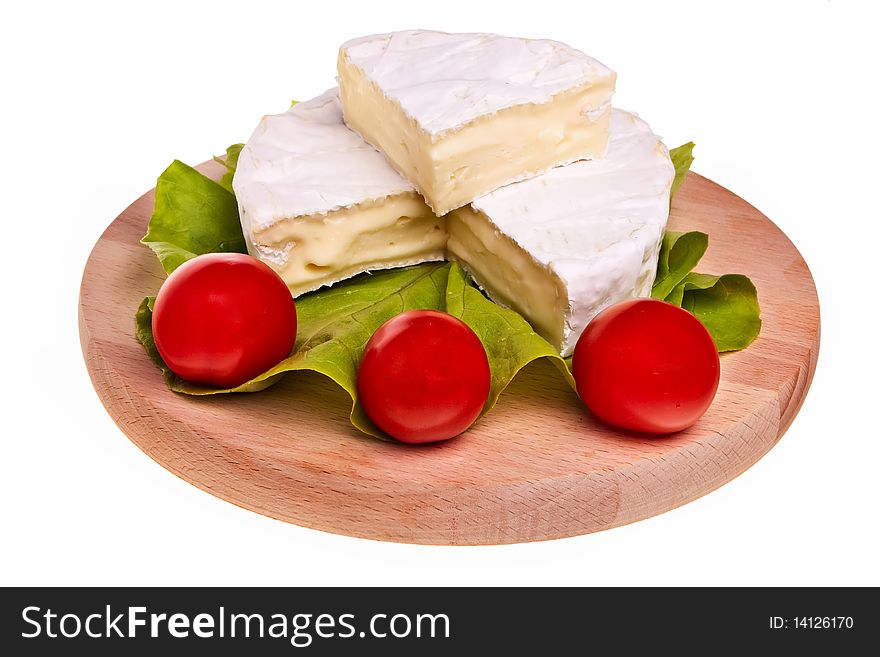 Round camembert cheese on wooden board with lettuce and tomatoes. Round camembert cheese on wooden board with lettuce and tomatoes.