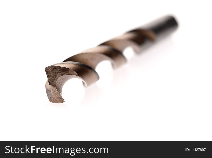 Shallow focus macro of a coated drill bit on a white reflective surface. Shallow focus macro of a coated drill bit on a white reflective surface