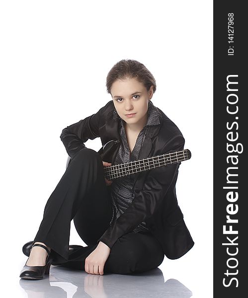 Seated girl posing in studio with a black electric bass guitar. Isolated on white background. Seated girl posing in studio with a black electric bass guitar. Isolated on white background