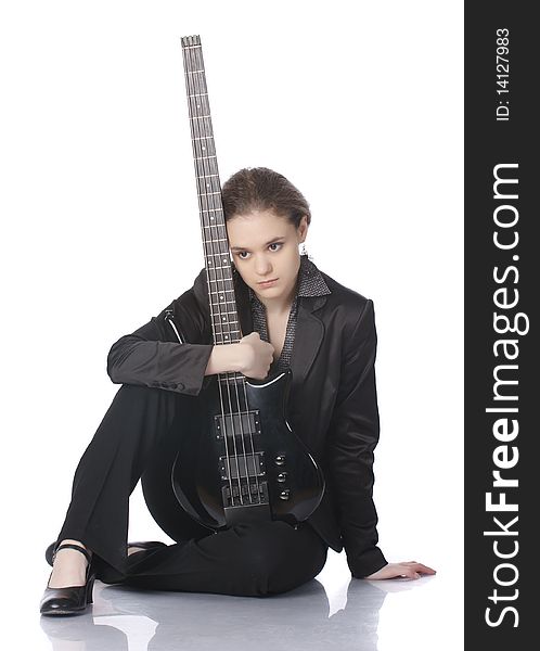 Seated girl posing in studio with a black electric bass guitar. Isolated on white background. Seated girl posing in studio with a black electric bass guitar. Isolated on white background