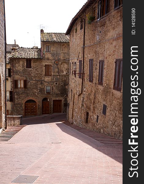 A narrow, sun-drenched street in the Tuscan village of San Gimignano. A narrow, sun-drenched street in the Tuscan village of San Gimignano