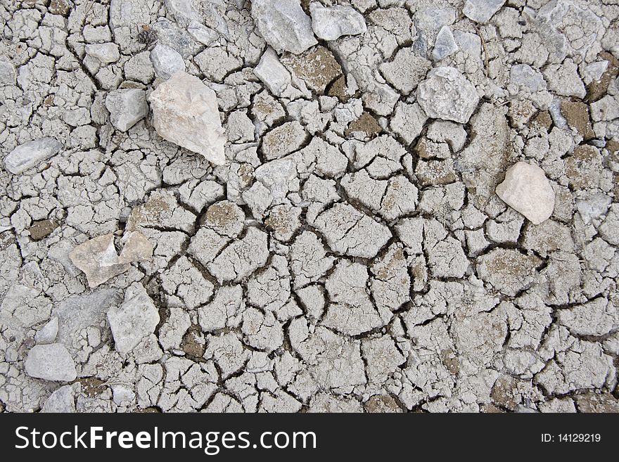 Dry cracked ground texture with stones