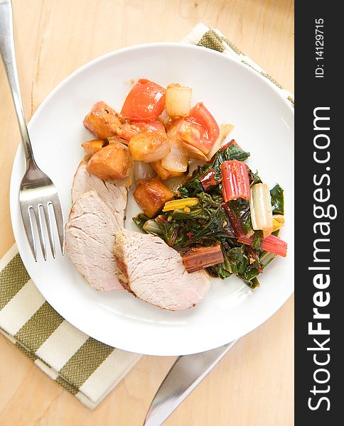 Pork tenderloin served with peach tomato compote and swiss chard