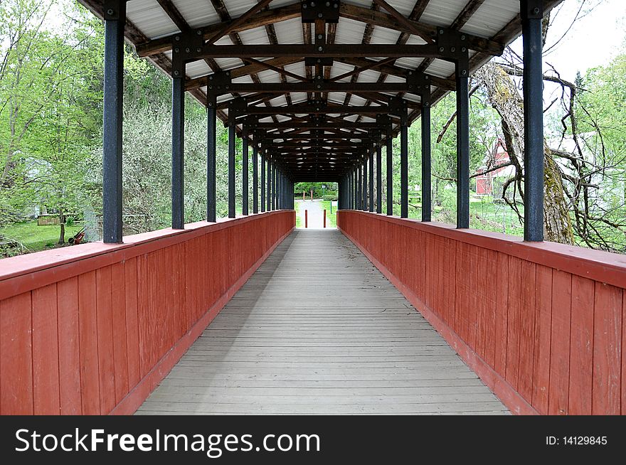 A picture of a covered footbridge taken from within the bridge