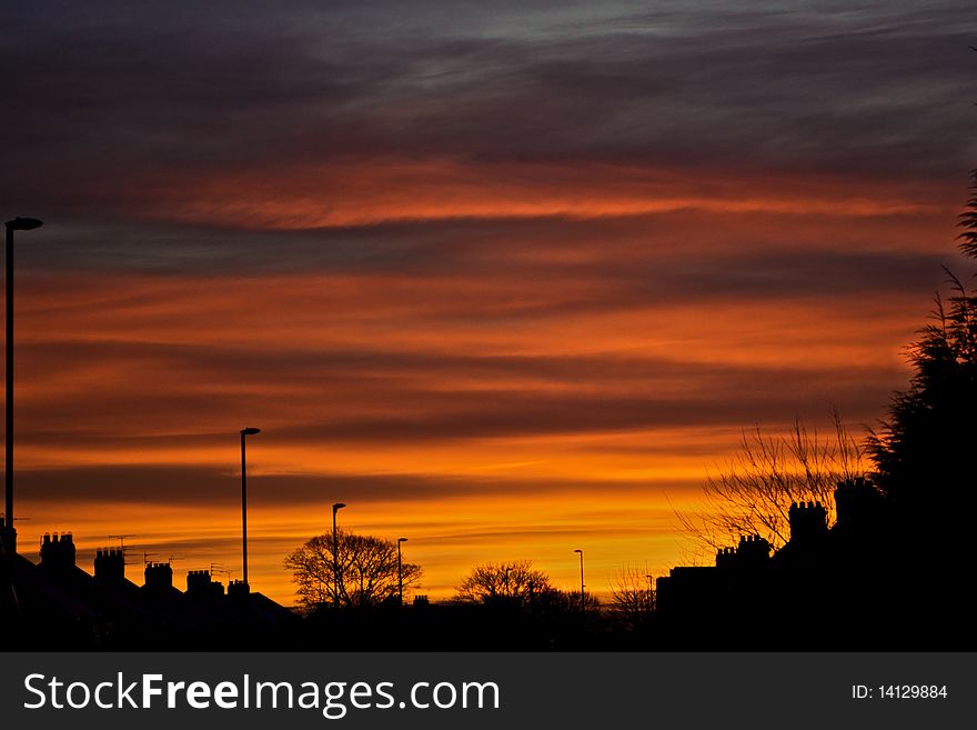 Houses silhouetted against a dramatic sunrise. Houses silhouetted against a dramatic sunrise