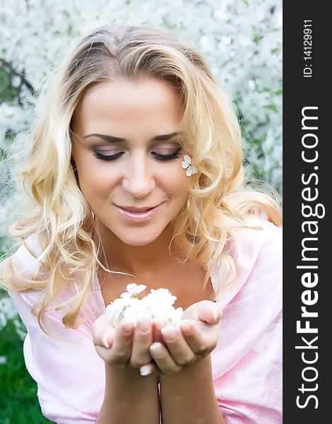 Cherry flowers in hands of young blonde model