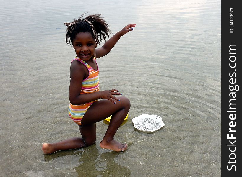 A beautiful black little girl playing on the beach. A beautiful black little girl playing on the beach.