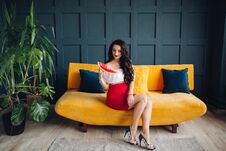Stylish Pregnant Woman Sitting On Orange Sofa And Posing Royalty Free Stock Photography