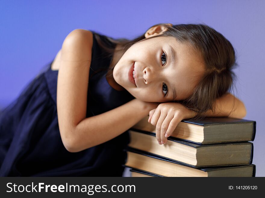 Cute Little Girl Is Reading A Book.