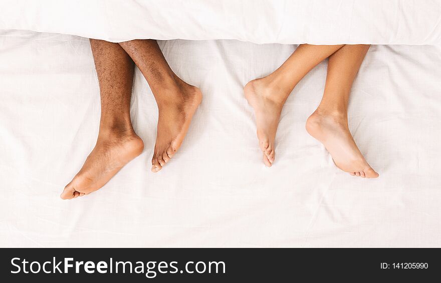 African-american couple ignoring each other in bed