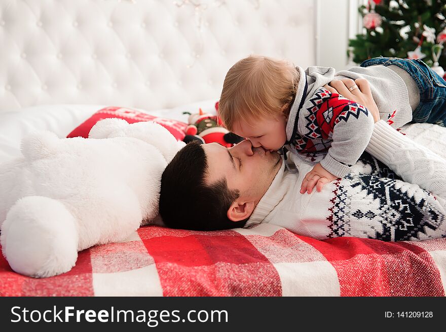 Portrait of cute happy father and son on christmas on bed.