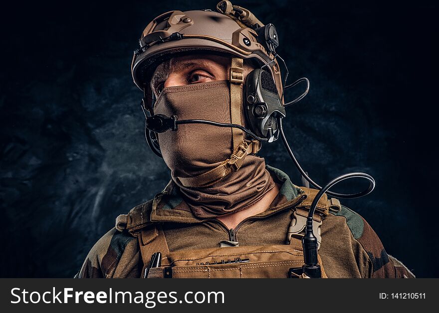 Close-up portrait. Private security service contractor in camouflage helmet with walkie-talkie.