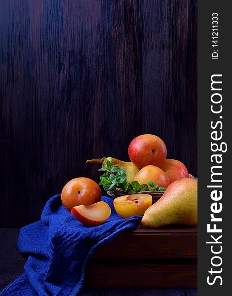 Red And Yellow Plums, Pears And Mint On A Wooden Table