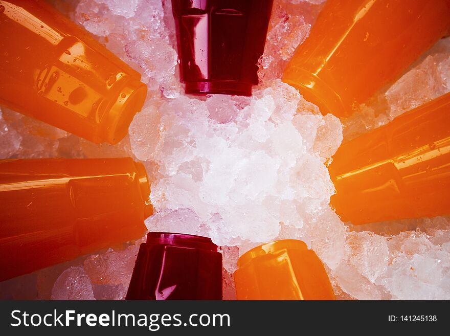 Orange juice and colorful sweet water on ice crystals in the top view.Popular drinks in the summer
