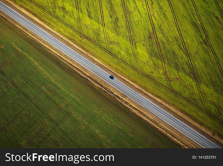 View From The Height On The Car Driving Along A Rural Road Between Two Fields