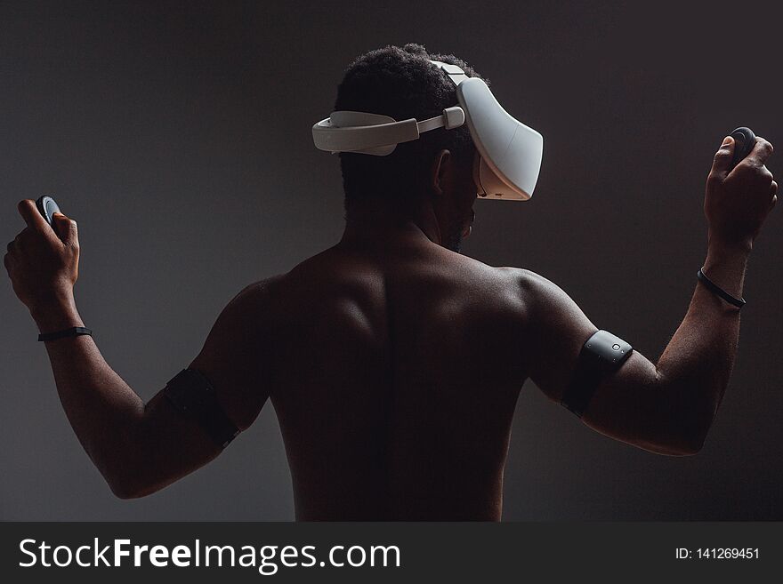 Backside Of African Male Muscular Athlet With Naked Torso Using Vr Headset