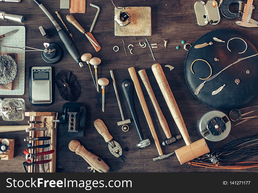 Top view photo. table is full of tools for making, repairing adornmnet