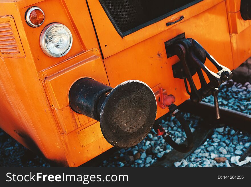 Abstract of a small orange locomotive, focus on lights and metal parts. Abstract of a small orange locomotive, focus on lights and metal parts