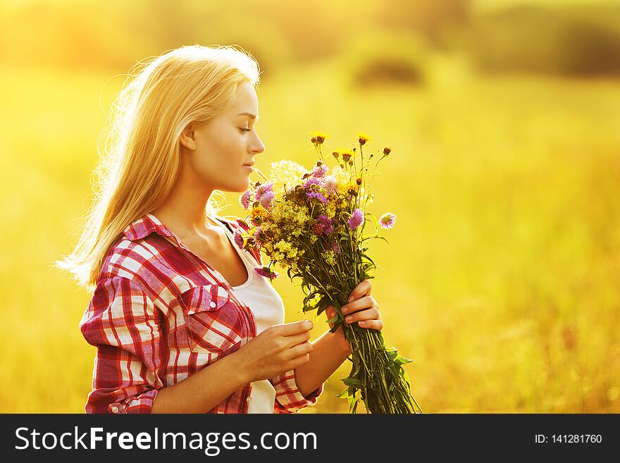 Beautiful girl with a bouquet of wild flowers