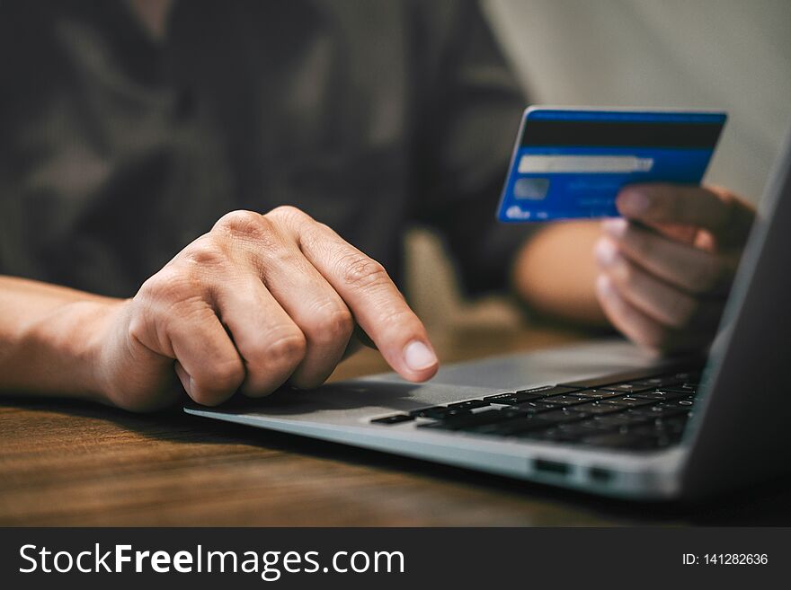 Businessman holding credit card and typing on laptop for online shopping and payment makes a purchase on the Internet, Online